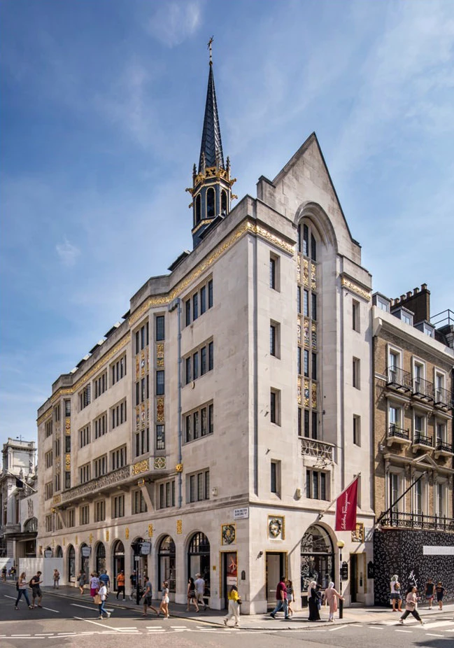 Exterior of the Arlington Insurance Office at 24 Old Bond Street, London W1S 4AW, featuring a distinctive spire, ornate architectural details, and a busy street scene with pedestrians.